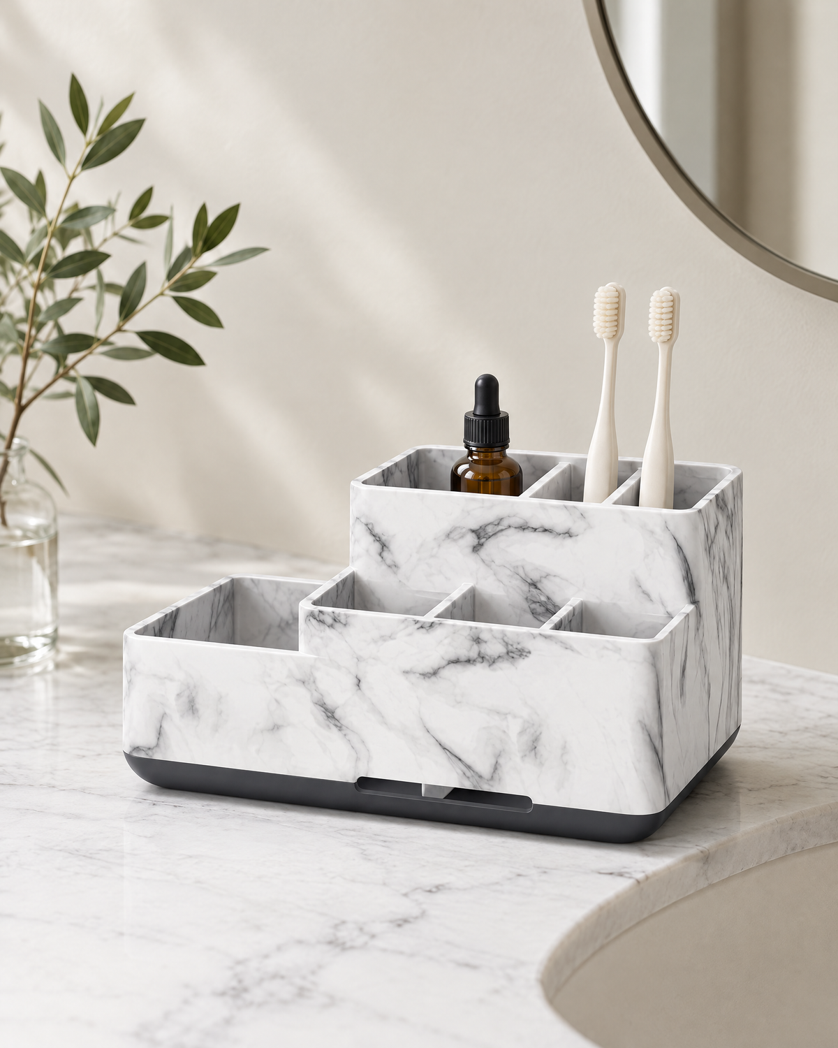 Marble-effect bathroom counter organiser with six compartments, holding bone-white toothbrushes and an amber dropper bottle